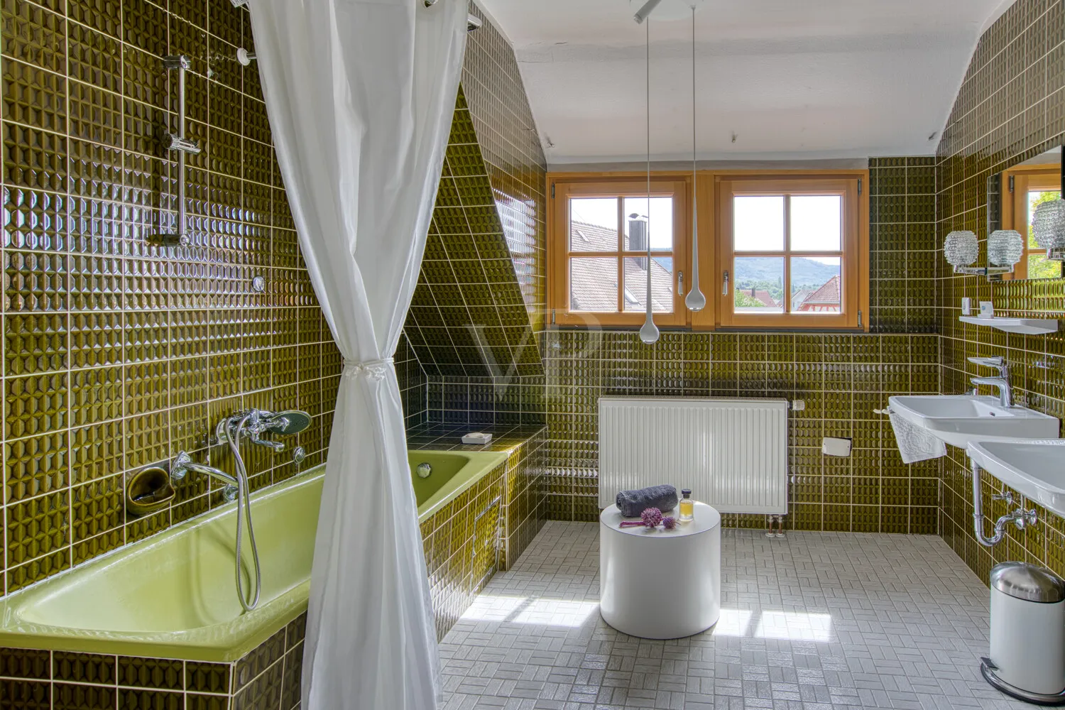 Geräumiges Tageslichtbad der Dachgeschosswohnung mit Wanne, Doppelwaschtisch und Fernblick