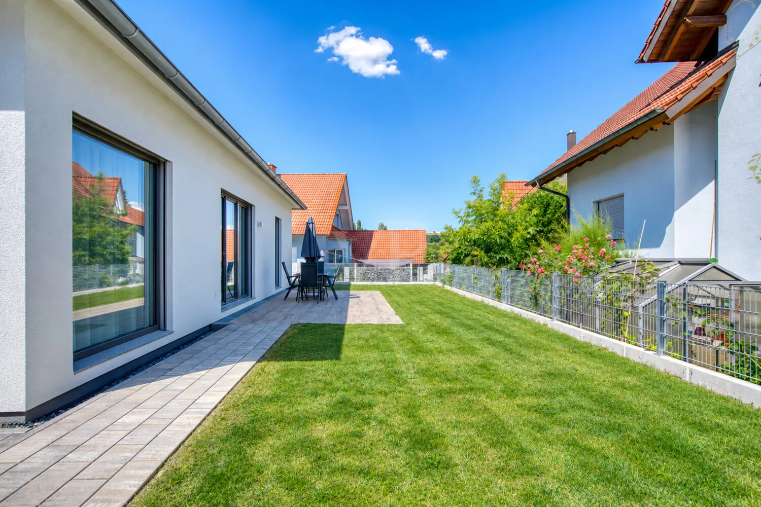 Moderner Garten mit Rasen und Terrasse