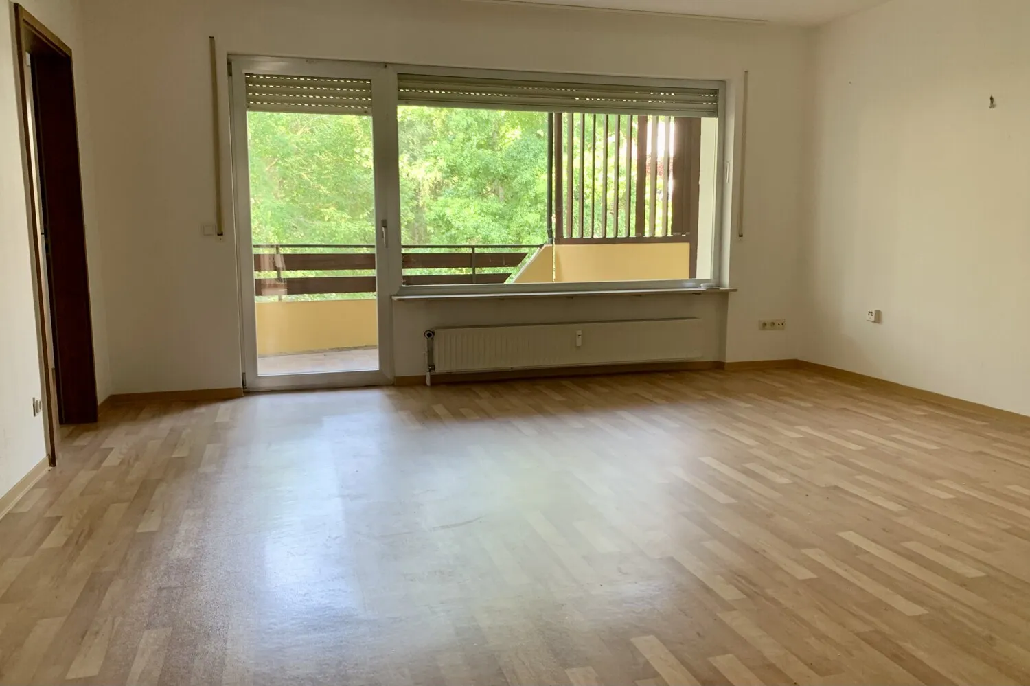 Wohnbereich mit Zugang zur Küche und Balkon