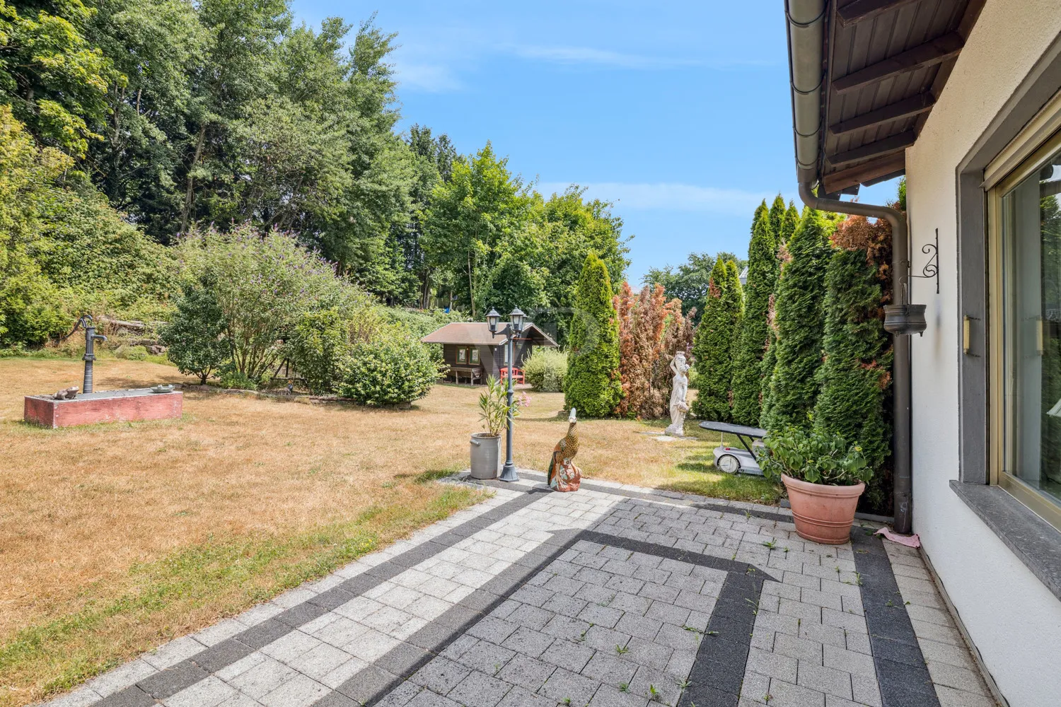 Terrasse mit Blick zum Nachbargrundstück mit Gartenhaus