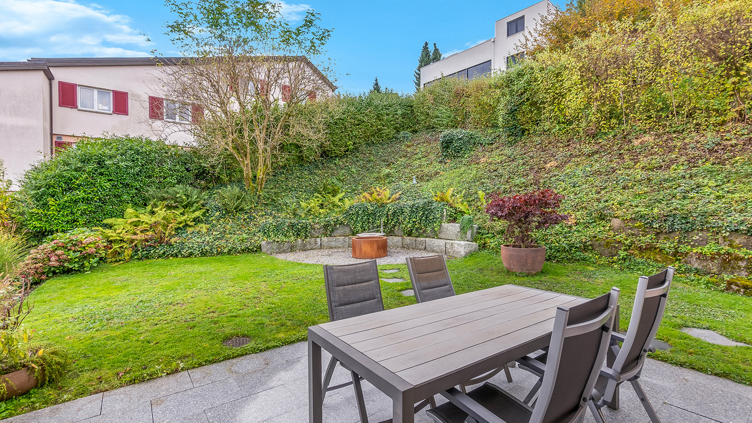 Ebenerdiger Sitzplatz nach Süden mit grosszügigem Gartenumschwung