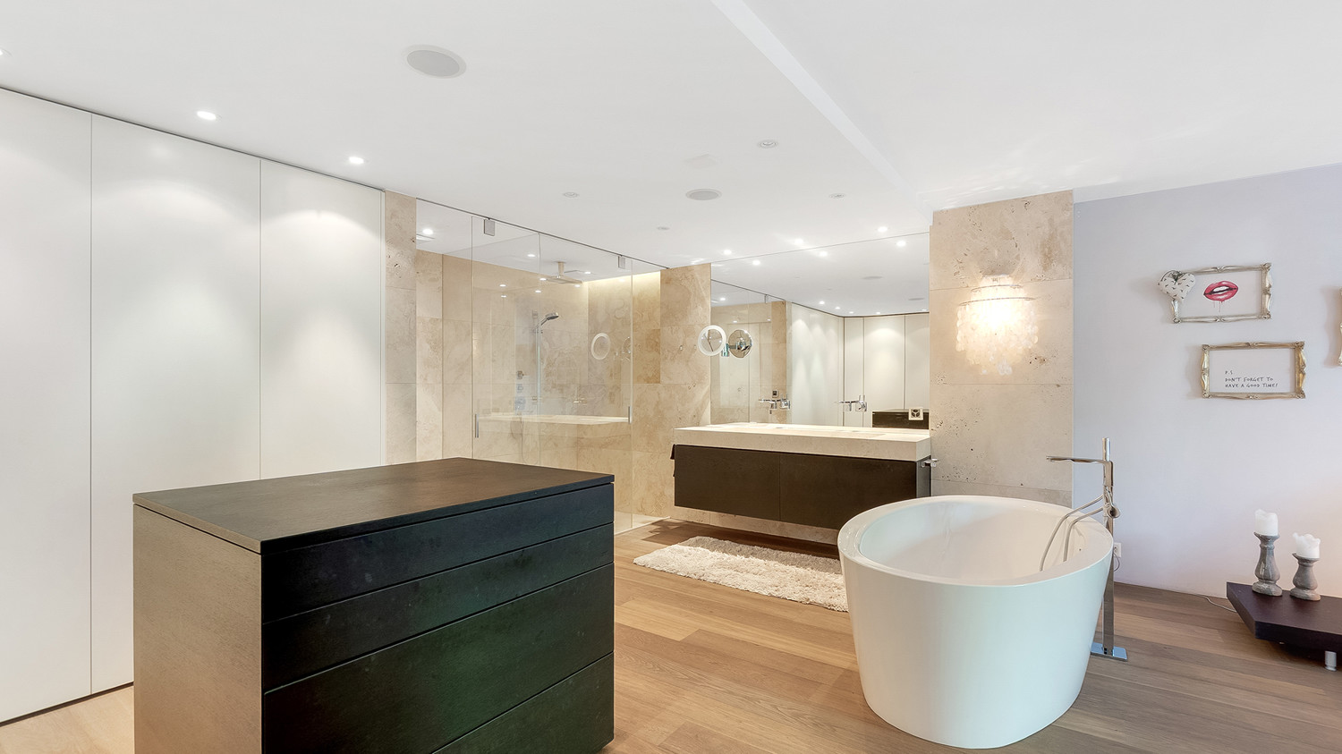 Freistehende Badewanne, Lavabo und durch Glaswand abgetrennte Dusche und WC