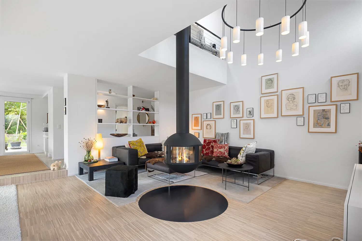 Lichtdurchflutetes Wohnzimmer mit Galerie und hängendem Schwedenofen