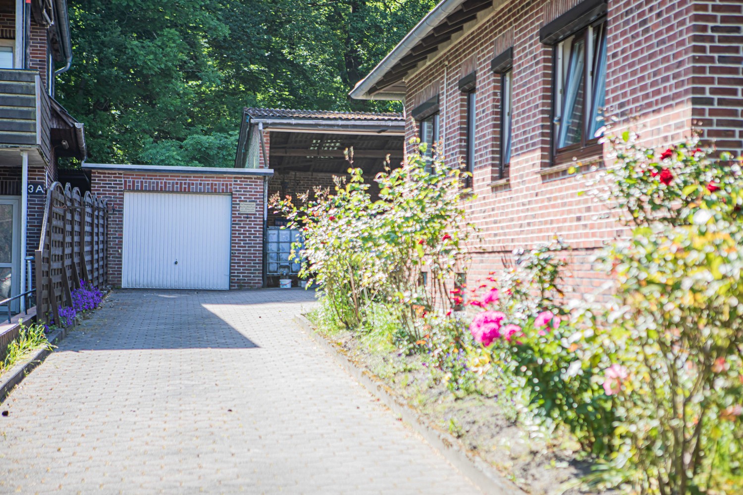 Einfahrt mit Blick auf Garage und Lager / Carport