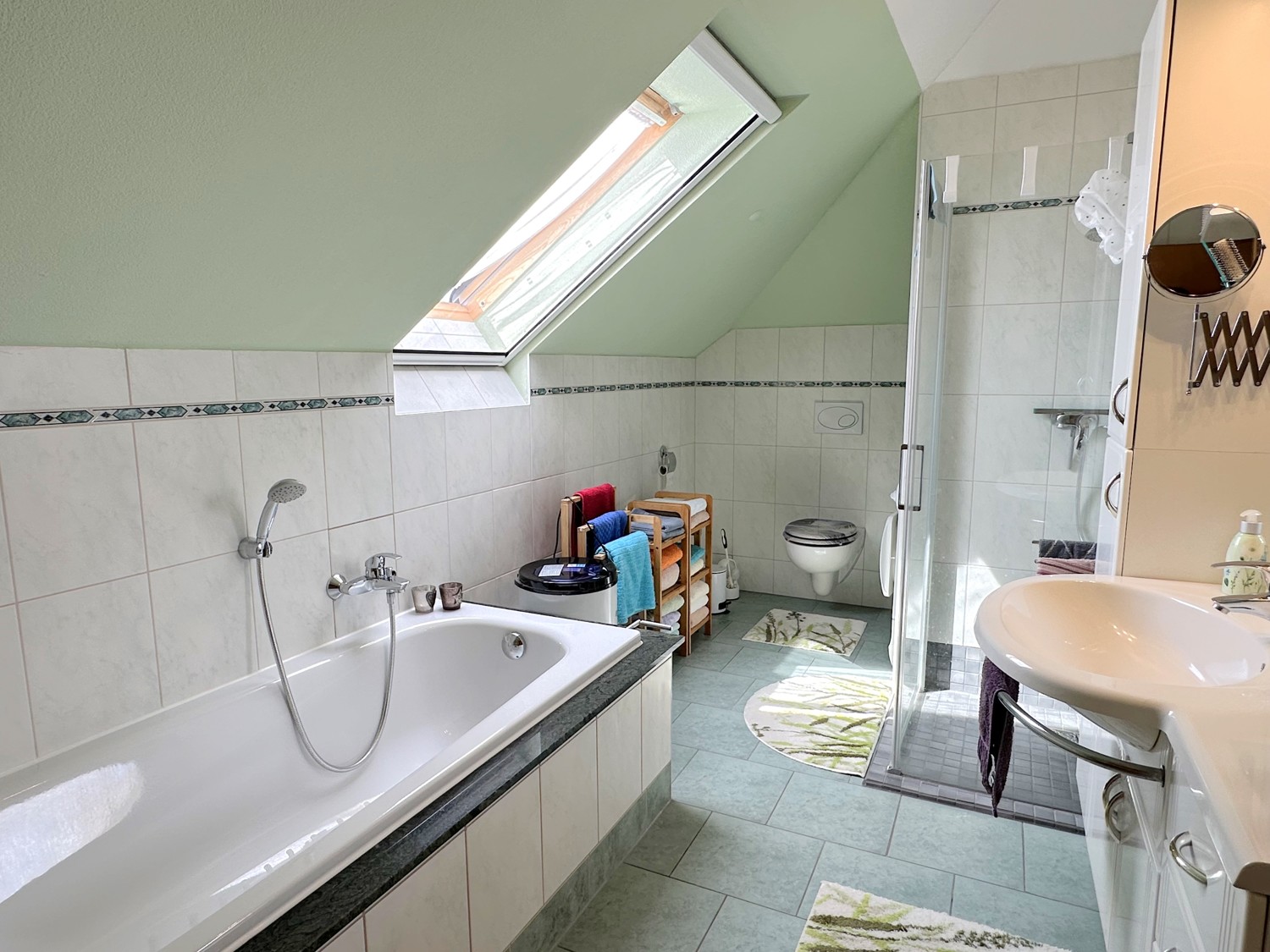 Badezimmer mit Badewanne und Dusche im Dachgeschos