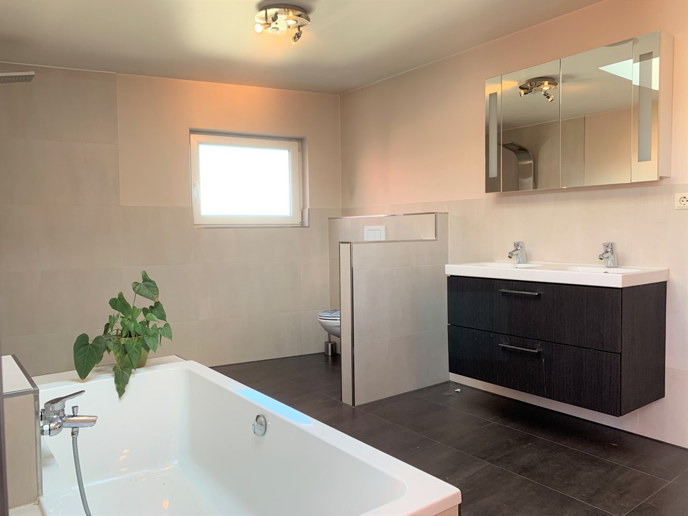 Modernes Badezimmer mit eingelassener Badewanne und bodentiefer Dusche im Obergeschoss