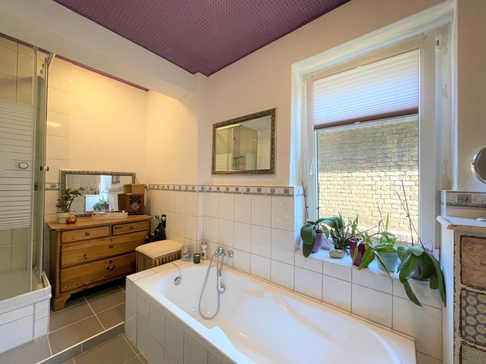 Badezimmermit Badewanne und Dusche der Wohnung im Seitenflügel