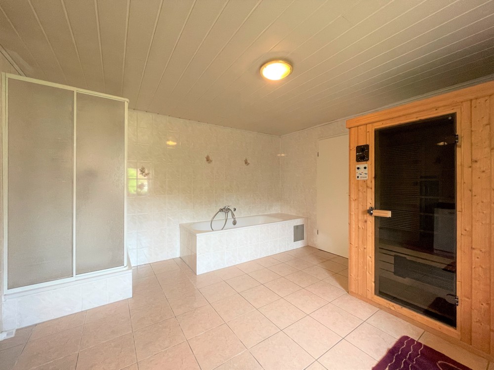 geräumiges Badezimmer mit Badewanne, Dusche und Sauna im Seitengebäude