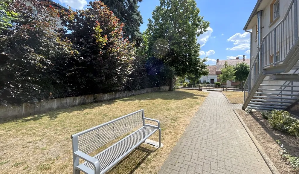 seitliche Grünanlage mit Sitzmöglichkeiten