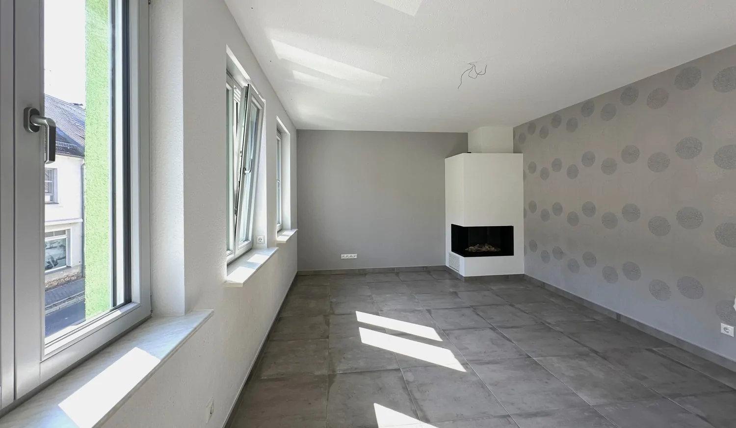 lichtdurchflutetes Wohnzimmer mit modernem Kamin