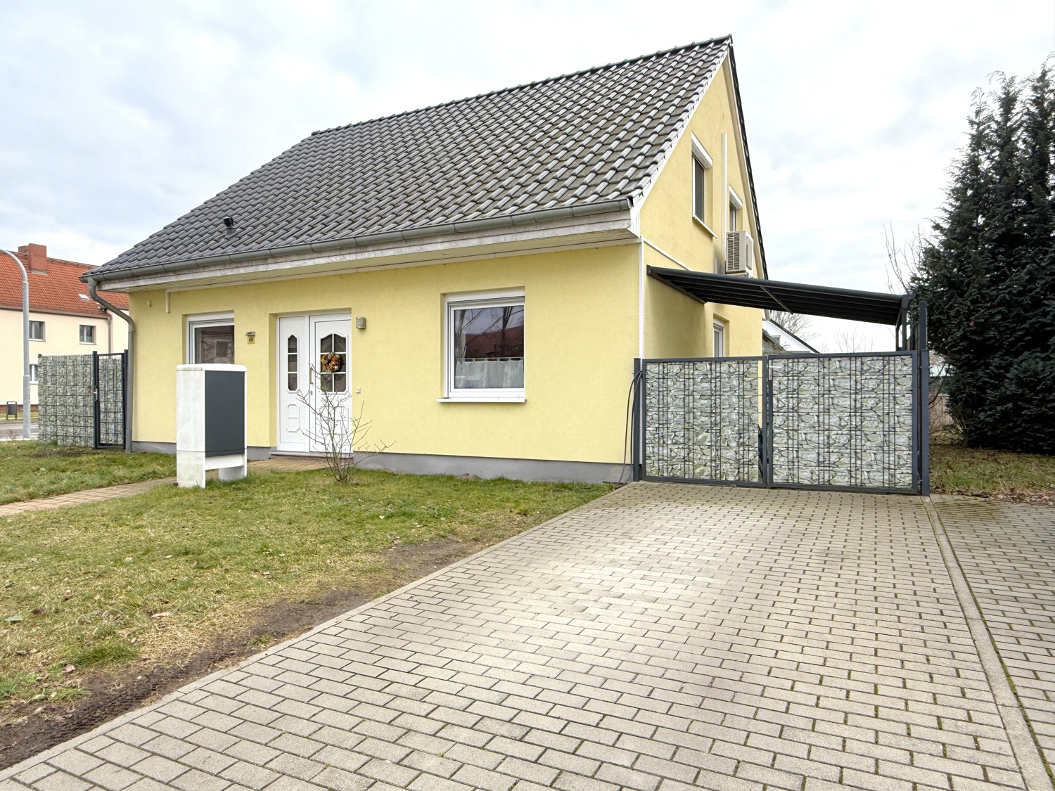 gepflasterte Auffahrt mit angrenzendem Carport