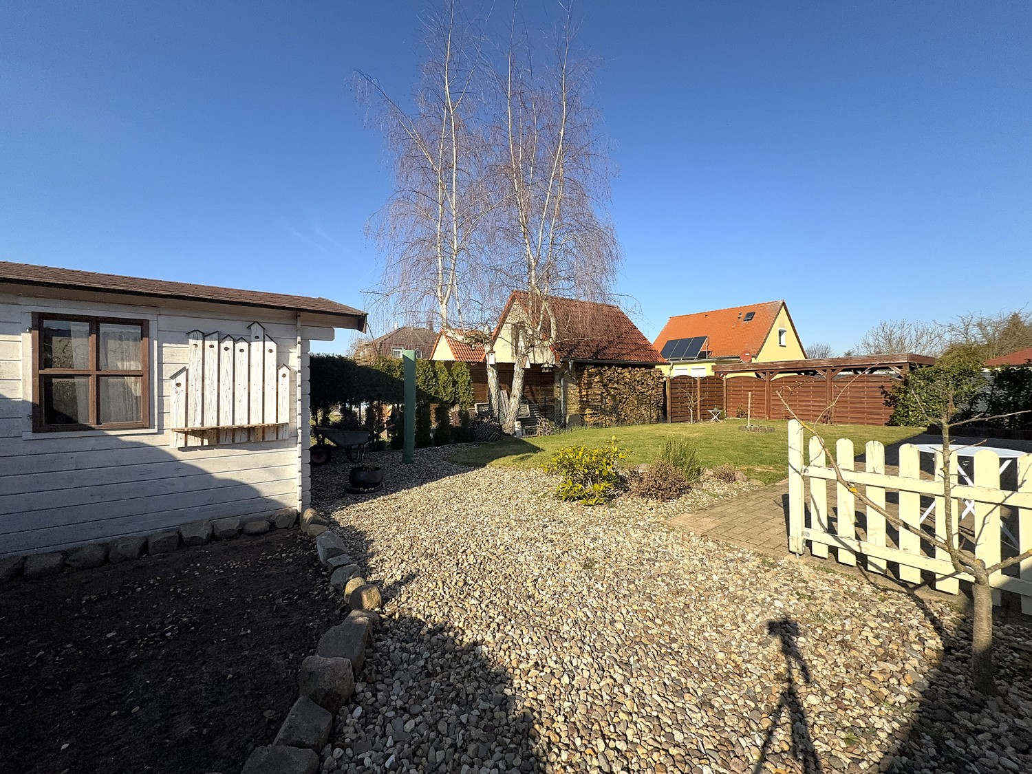 pflegeleichter Garten mit angelegten Beeten und Schuppen