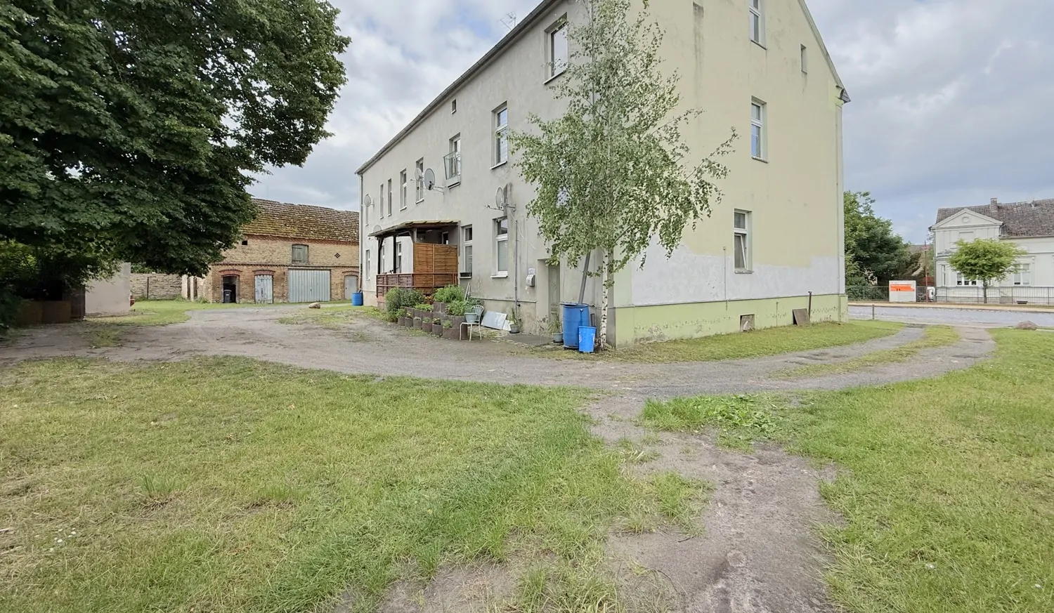 unbefestigter Innenhof mit zwei Grundstückszufahrten