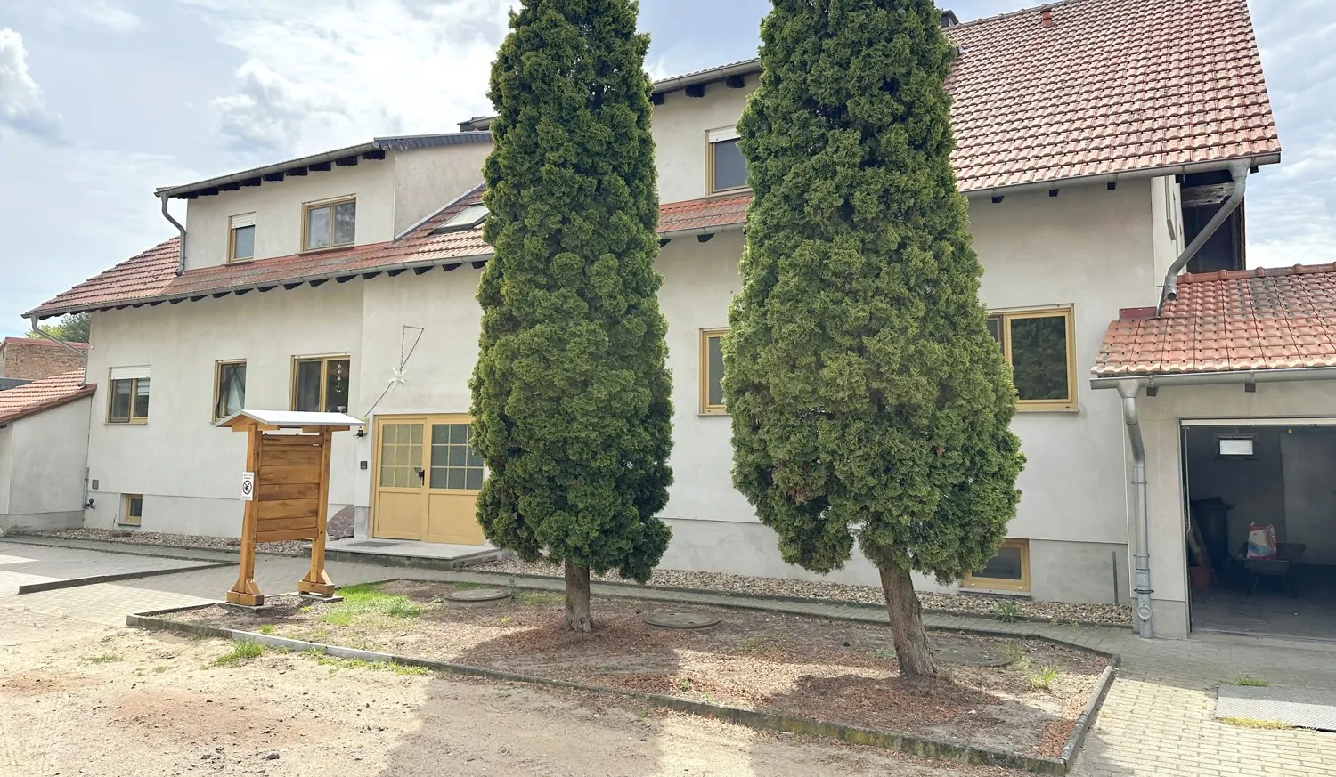 gepflasterte Stellplätze und Garagen vor dem Haus