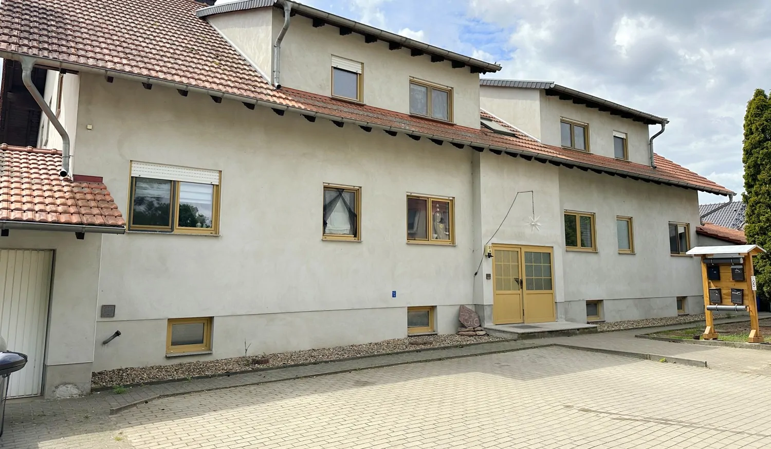 gepflasterte Stellplätze und Garagen vor dem Haus