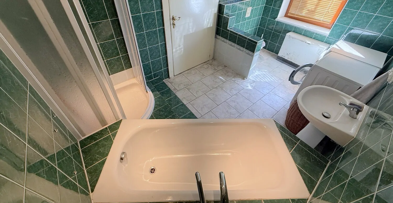 Badezimmer mit Badewanne und Dusche