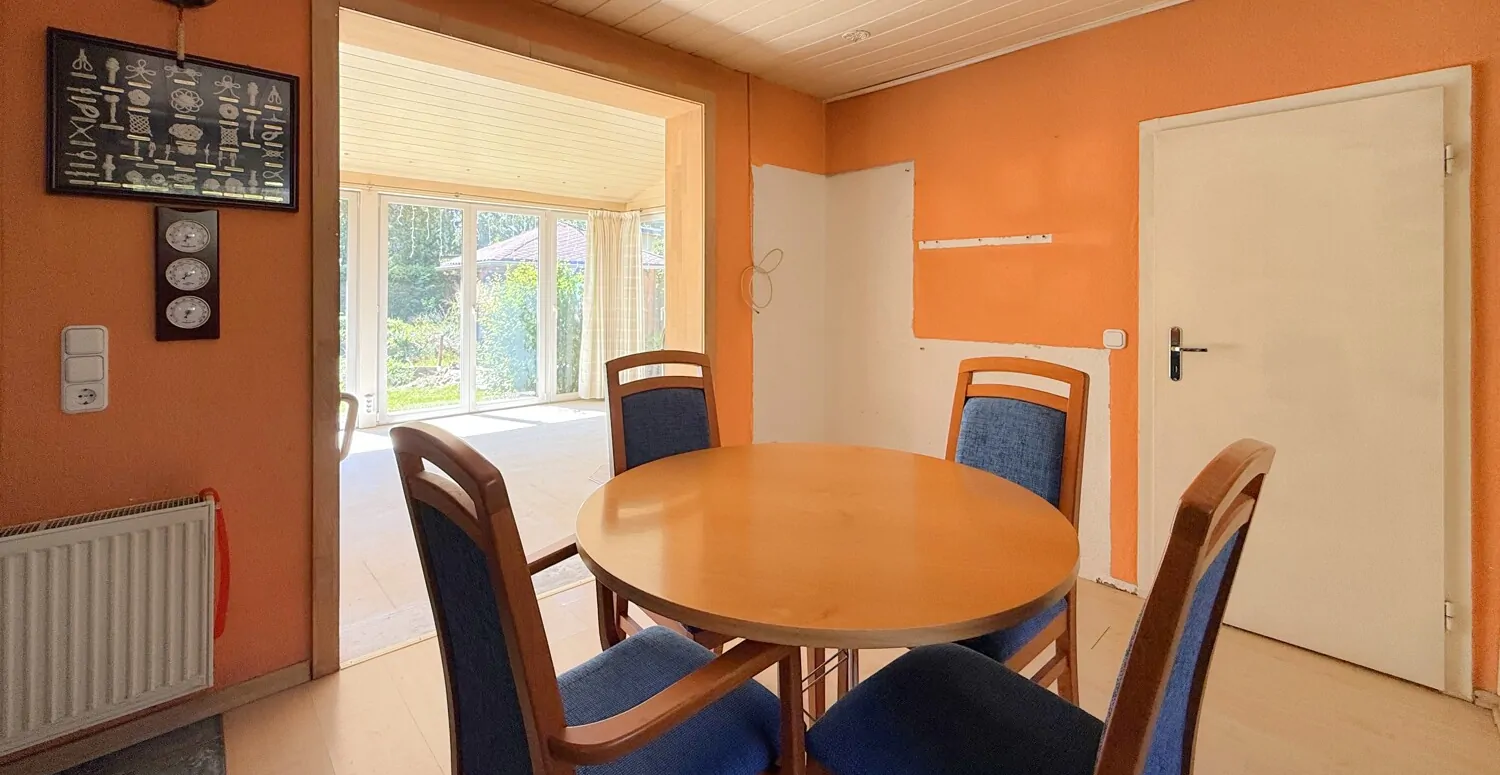 Essbereich mit großer Wandöffnung zum Wintergarten