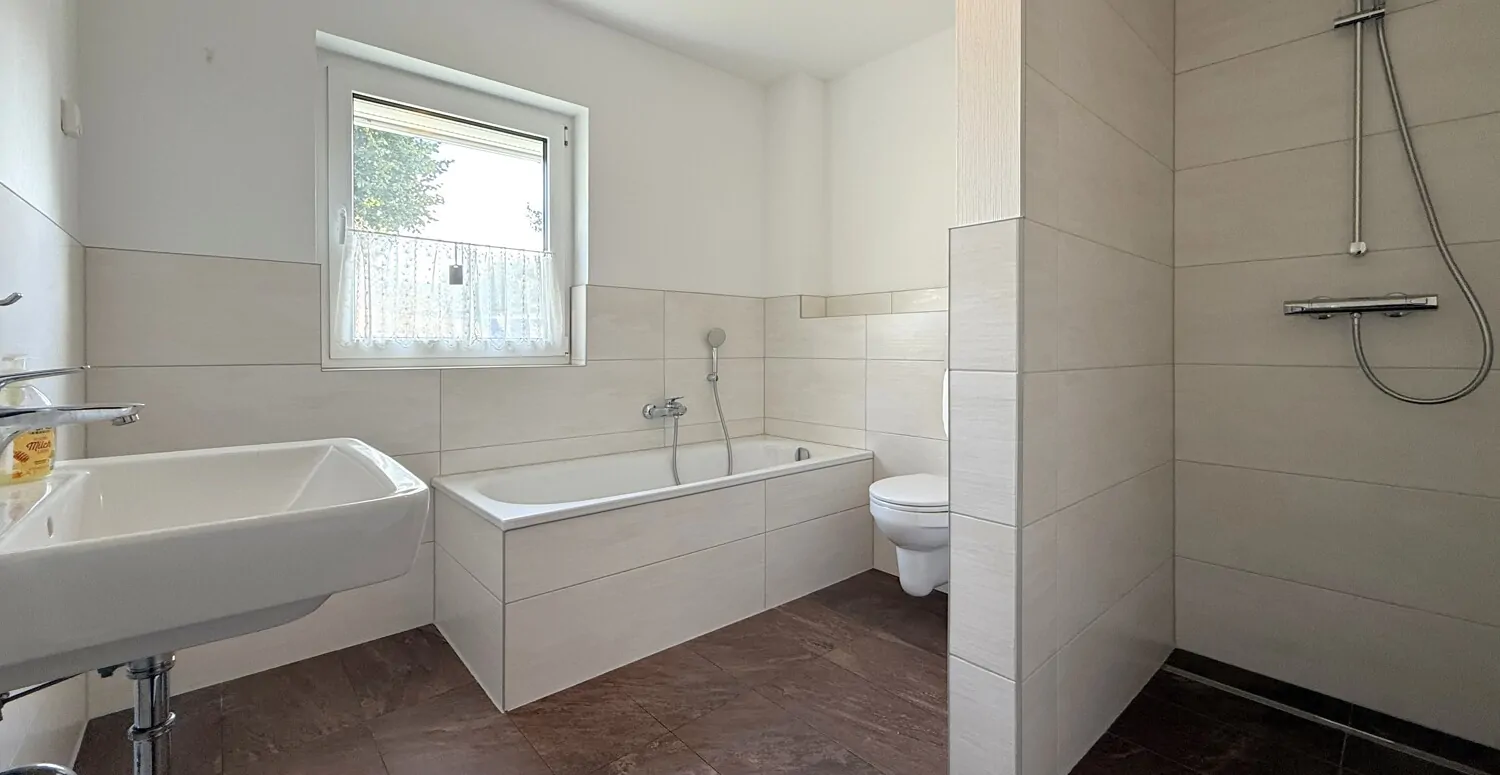 Badezimmer mit Badewanne und ebenerdiger Dusche