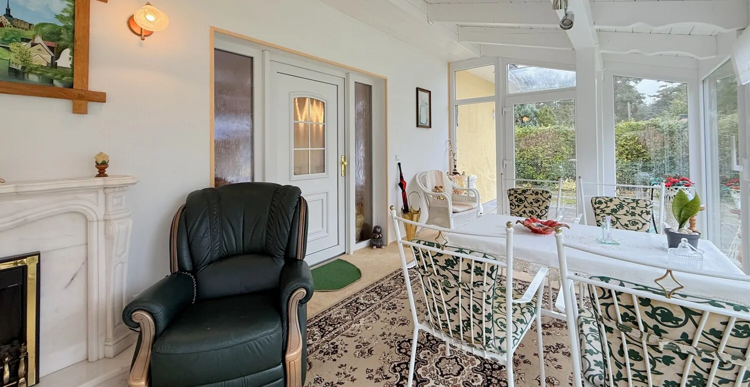 lichtdurchfluteter Wintergarten mit elektrischem Kamin