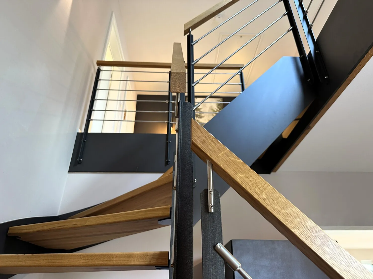 Offen gestalteter Treppenaufgang mit moderner Holz-Stahl-Konstruktion und Galeriecharakter