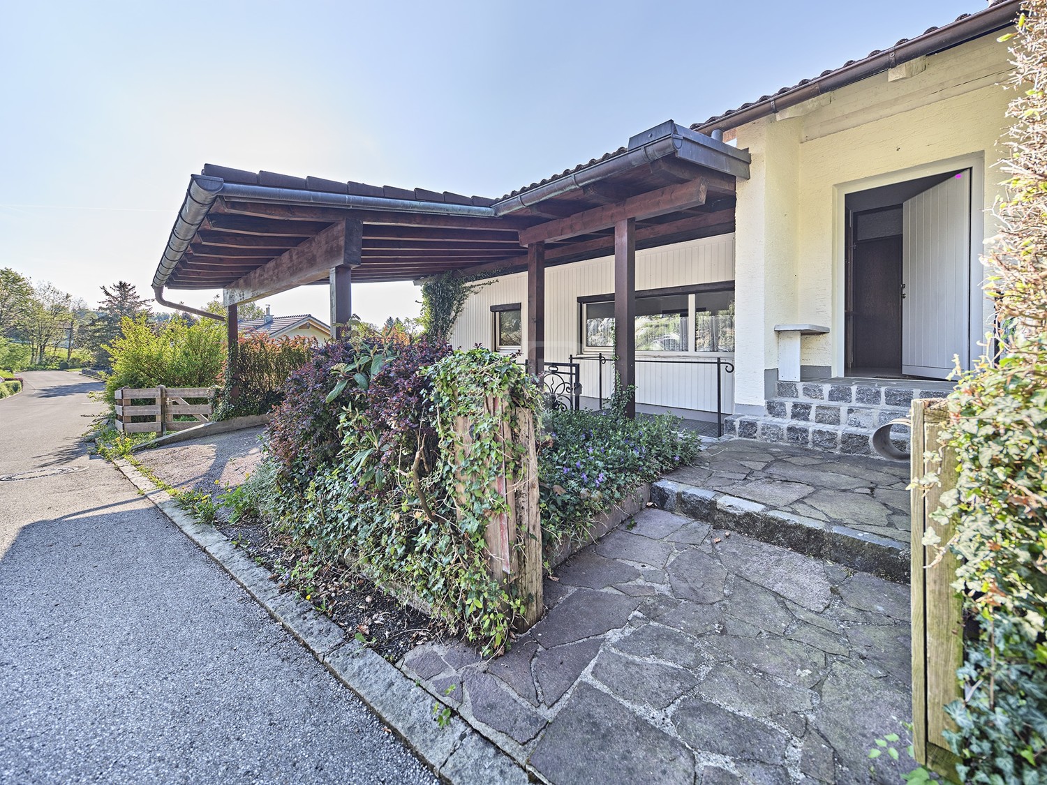 Hausfront mit Eingangsbereich und Vorgarten sowie Carport