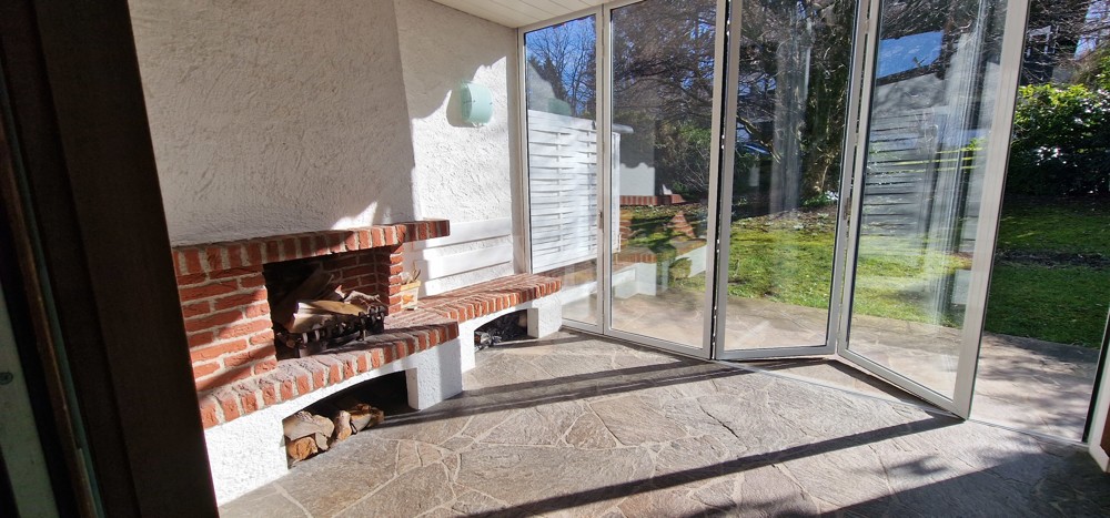 Überdachter Wintergarten mit Kamin