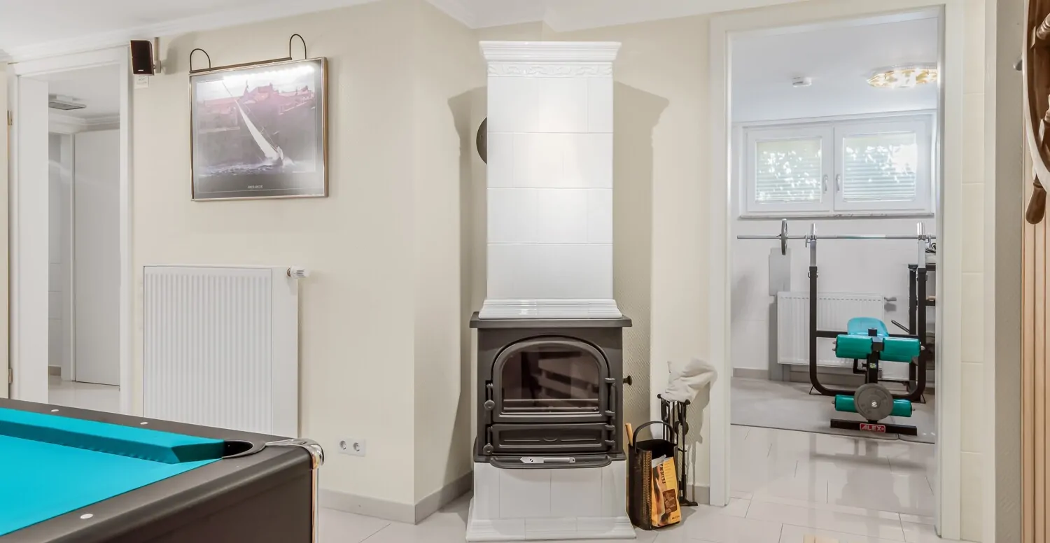 Blick auf den Kaminofen und zum Sportbereich