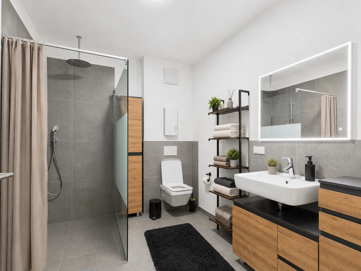 Badezimmer mit großer Dusche, Waschbecken und WC