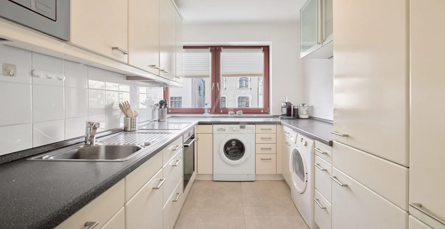 schlichte helle Küche mit Waschmaschinenanschluss...