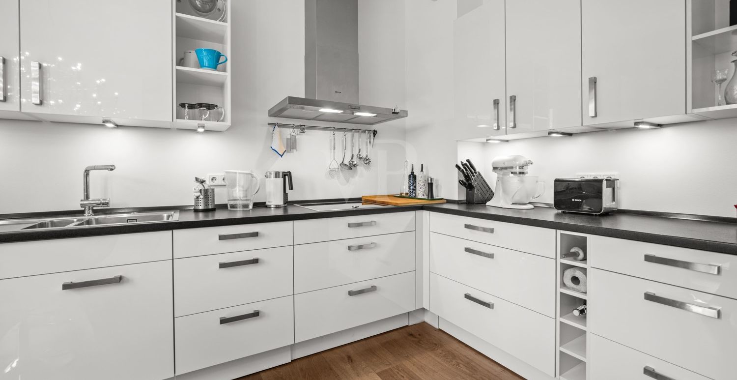moderne Einbauküche mit weißen Hochglanzfronten