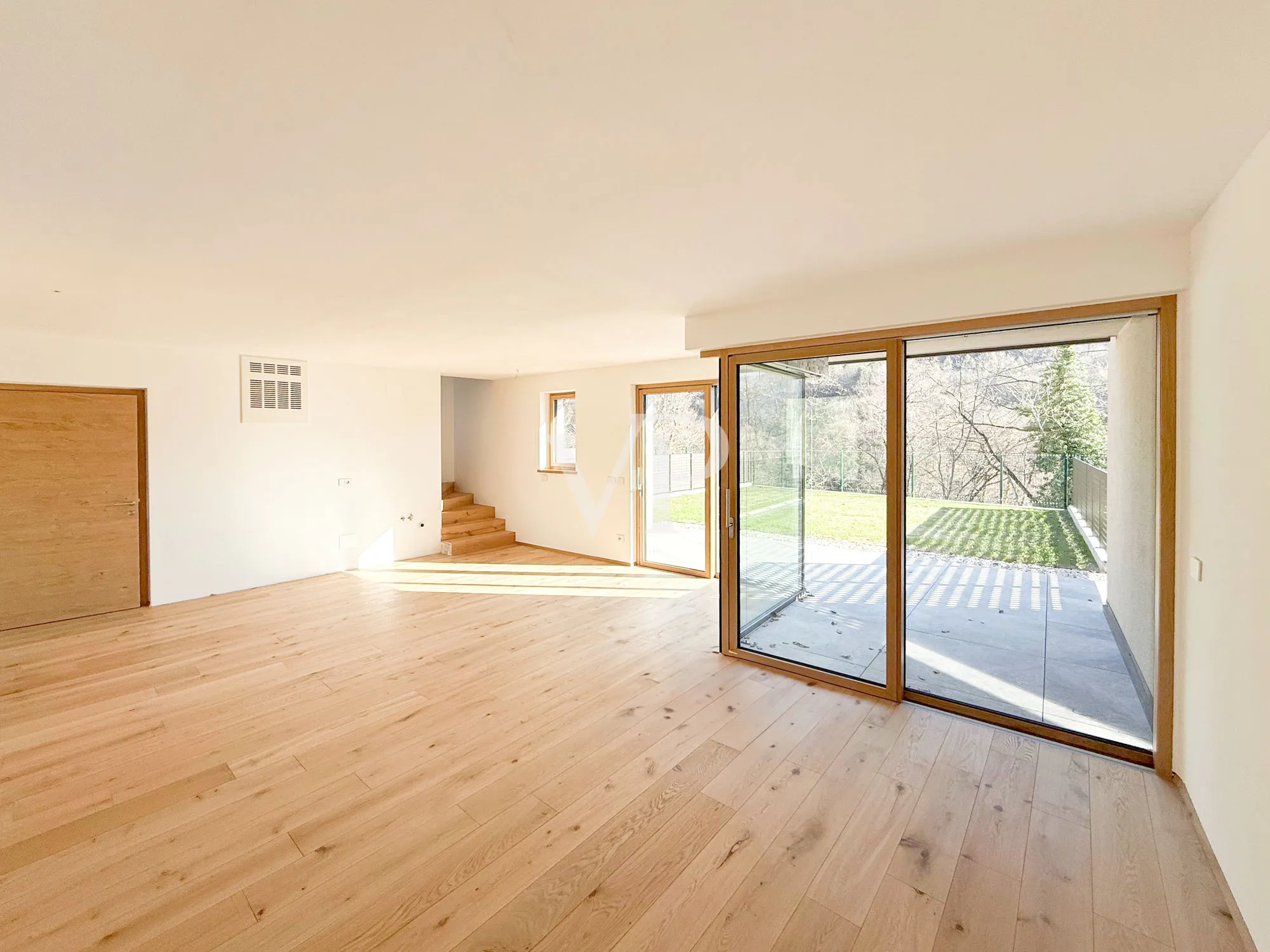 Elegante y moderno chalet adosado rodeado de vegetación.