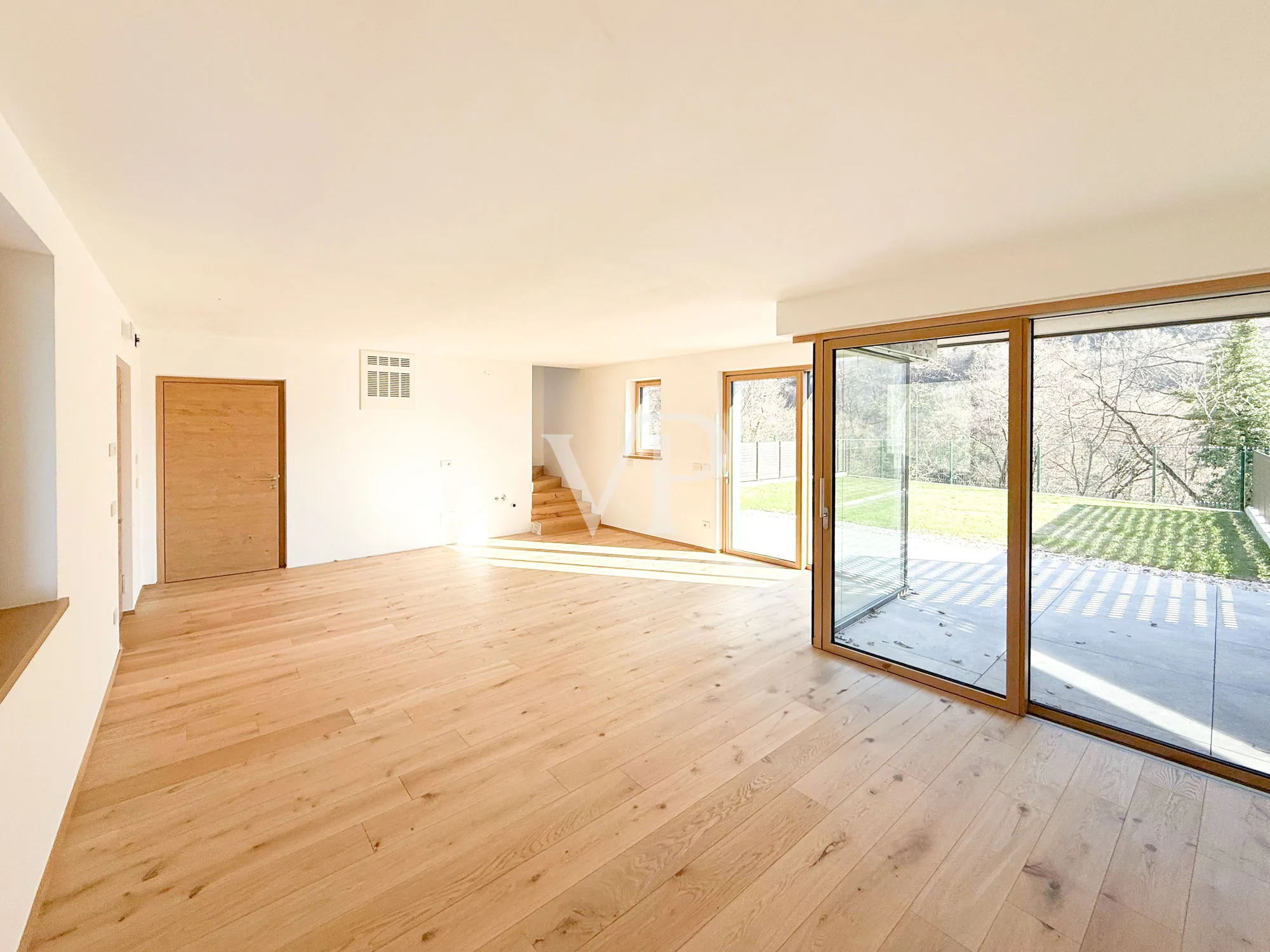 Elegante y moderno chalet adosado rodeado de vegetación.