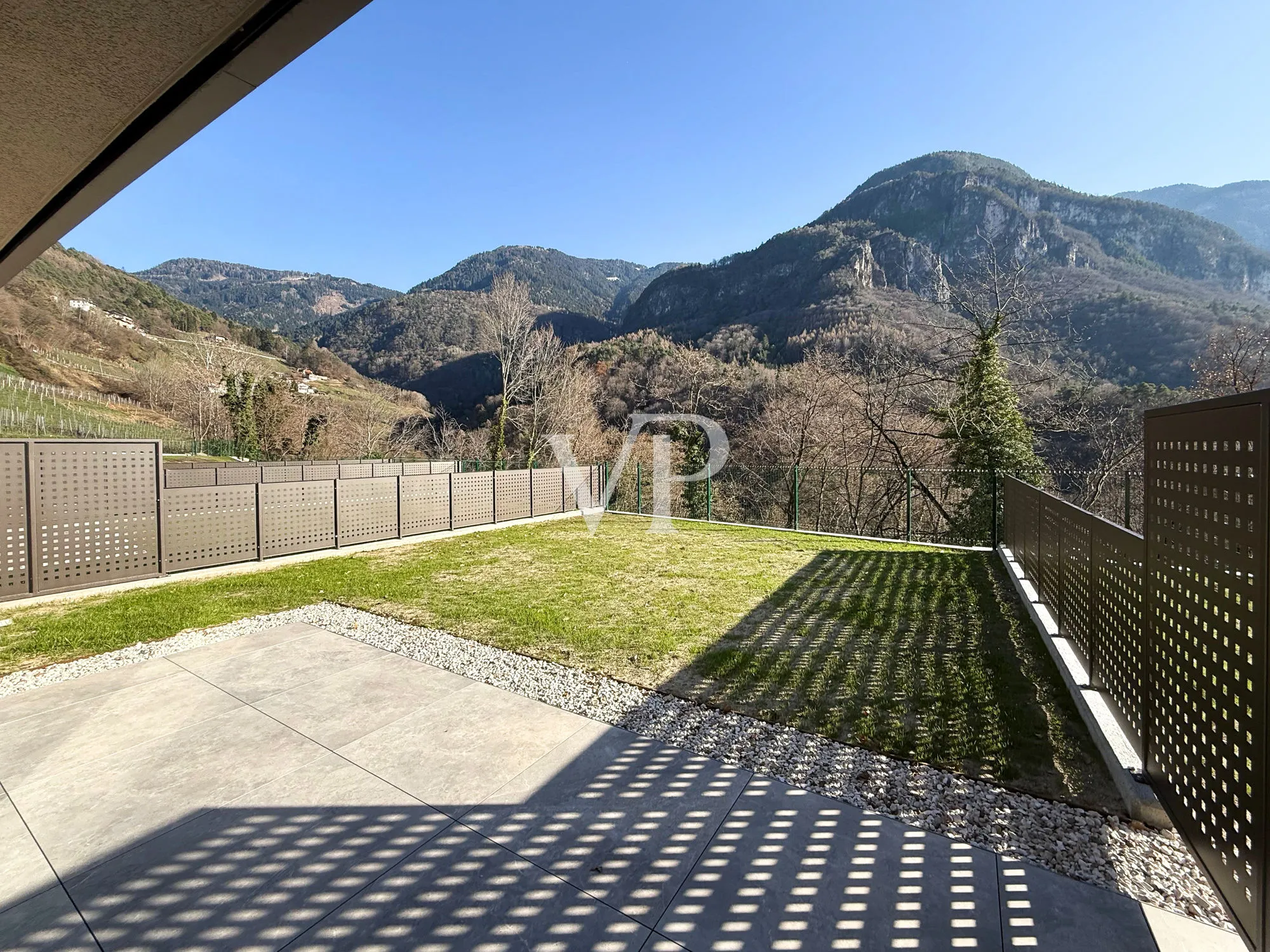 Elegante y moderno chalet adosado rodeado de vegetación.