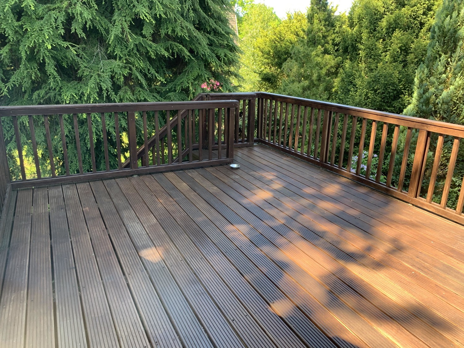 Sonnige Balkonterrasse mit Treppe zum Garten