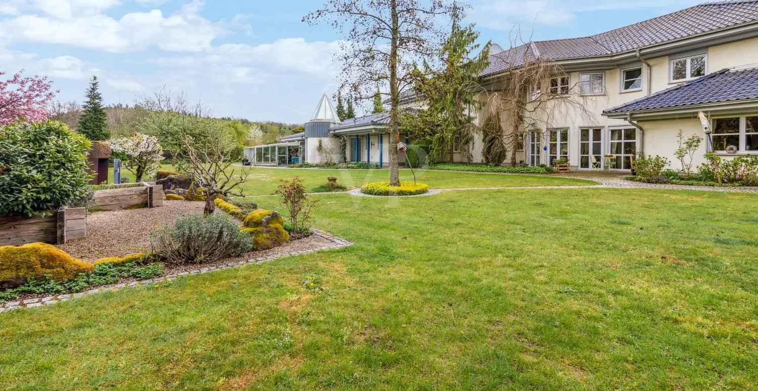 Blick auf den Kräutergarten und das Gewächshaus