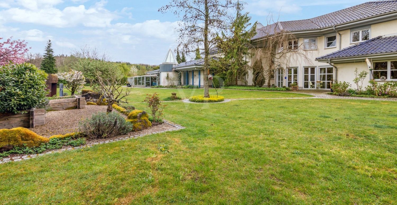 Blick auf den Kräutergarten und das Gewächshaus