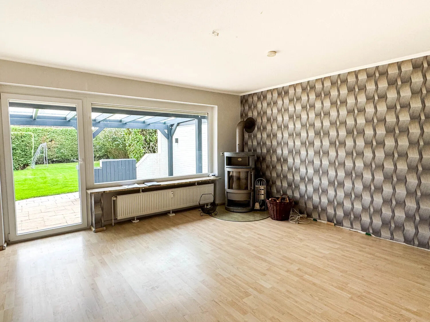 Wohnzimmer mit Kaminofen und Zugang zur überdachten Terrasse im Erdgeschoss