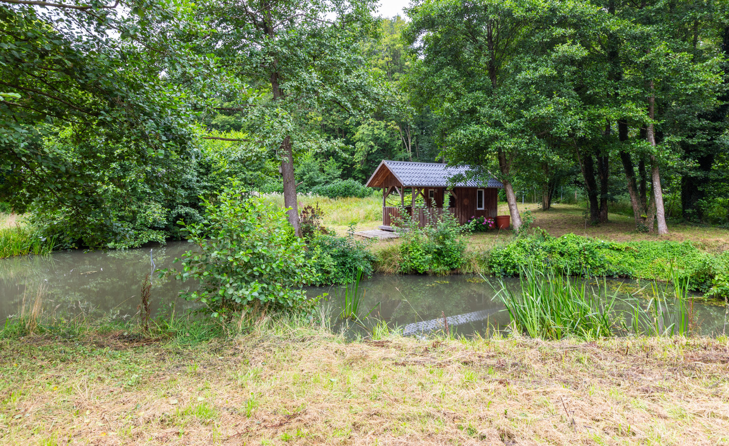 Teich und Gartenhaus mit überdachtem Freisitz