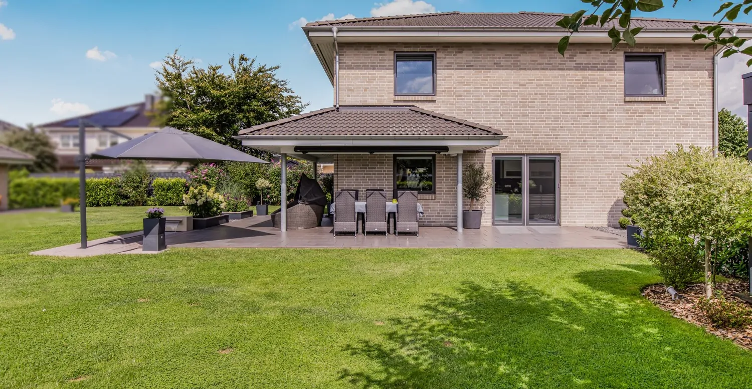 Seitliche Gebäude- und Terrassenansicht