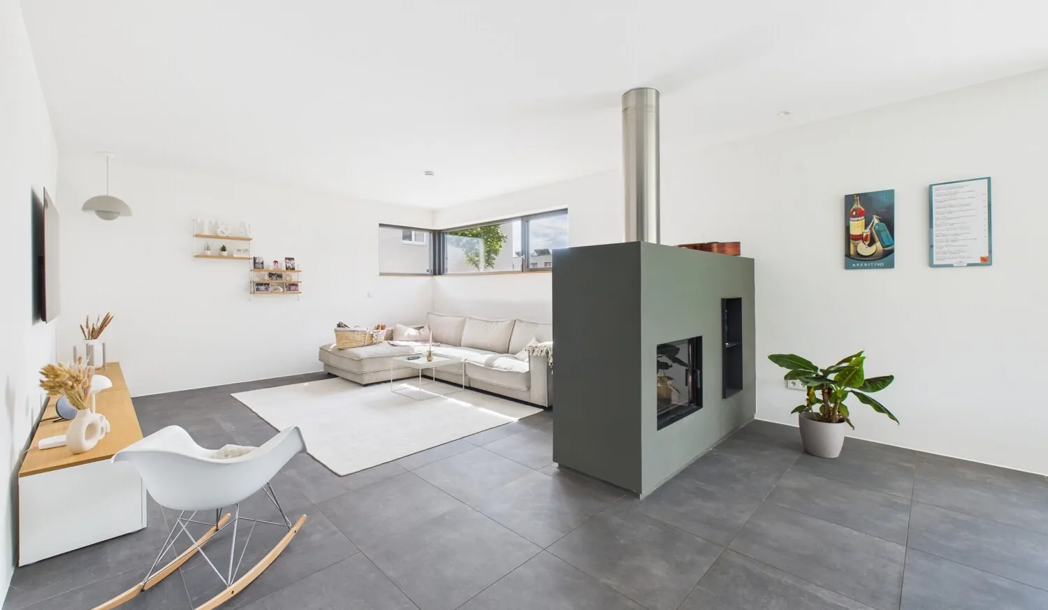 Wohnbereich mit raumteilenden S7-Kaminofen mit Sichtglas