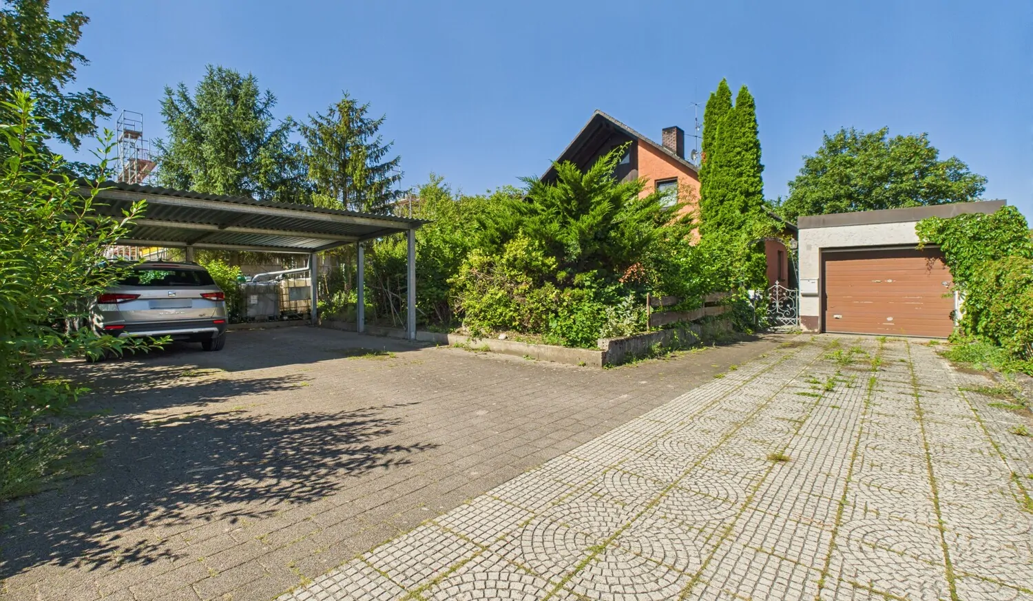 Einfahrt mit Carport und Garage