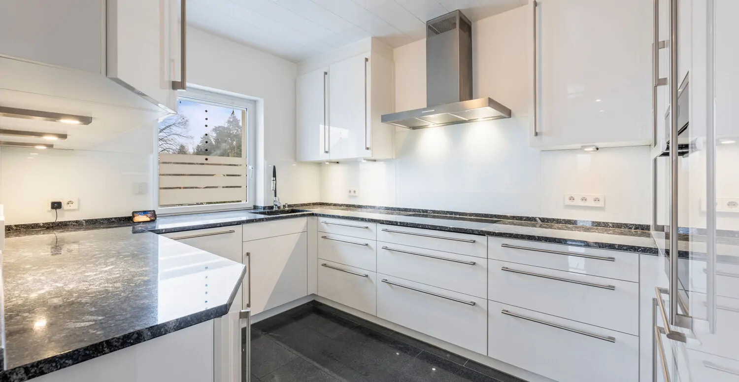 Moderne Einbauküche mit hochwertigen Elektrogeräten und Granit-Arbeitsplatte