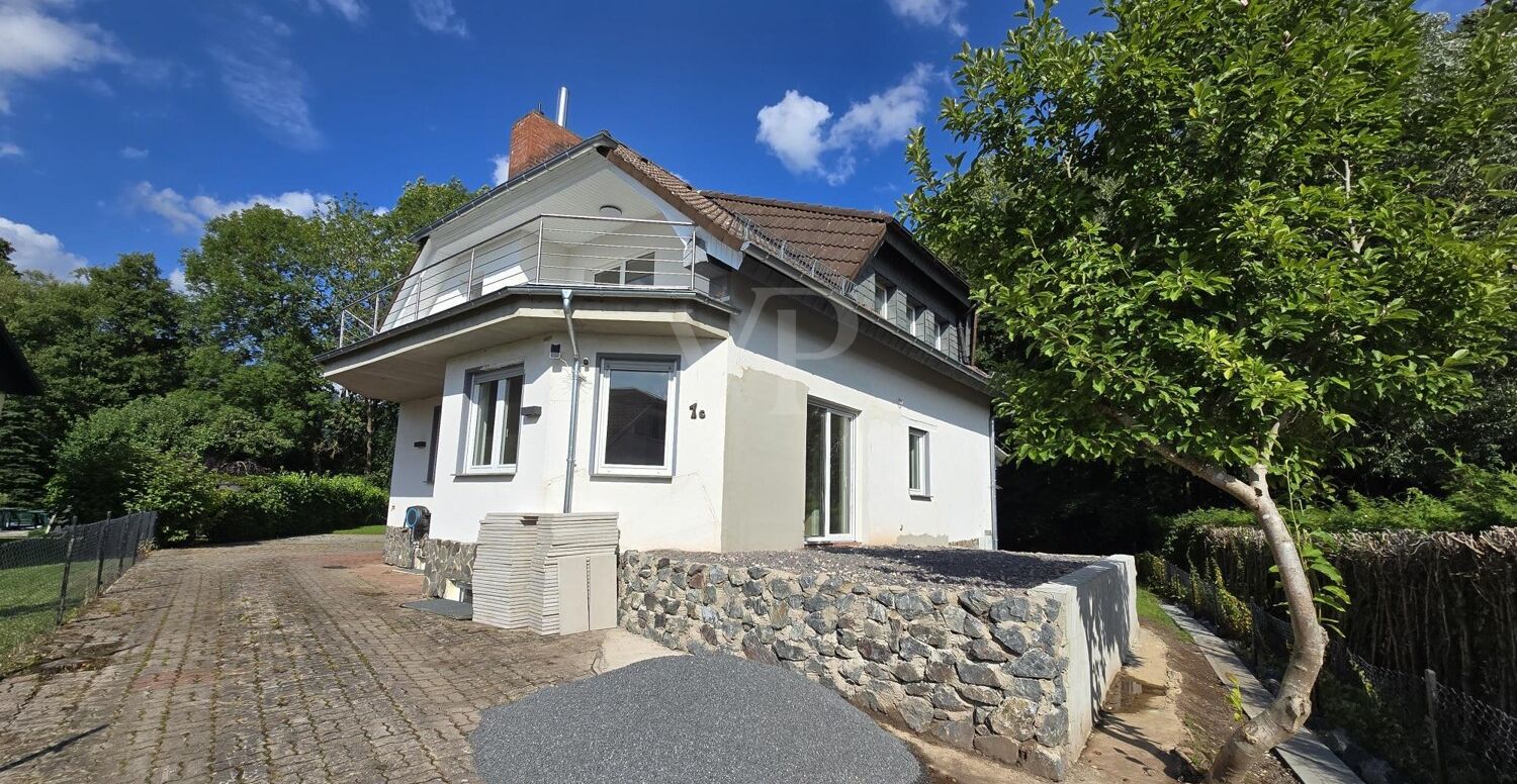 Ansicht Süden mit Einfahrt und Terrassenausbau vorbereitet