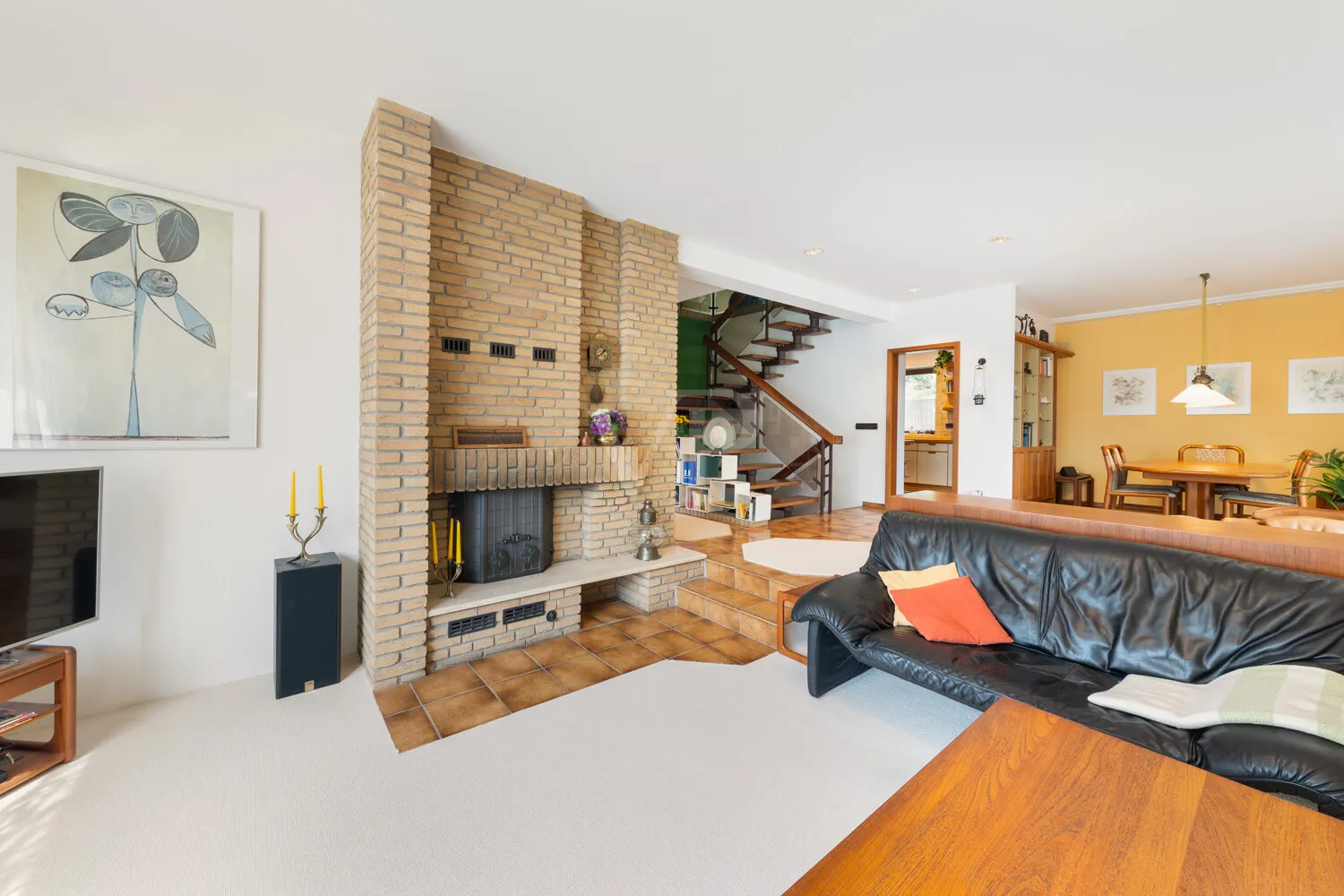 Blick vom Wohnzimmer mit Kamin zum Esszimmer mit angrenzender Süd-West-Terrasse