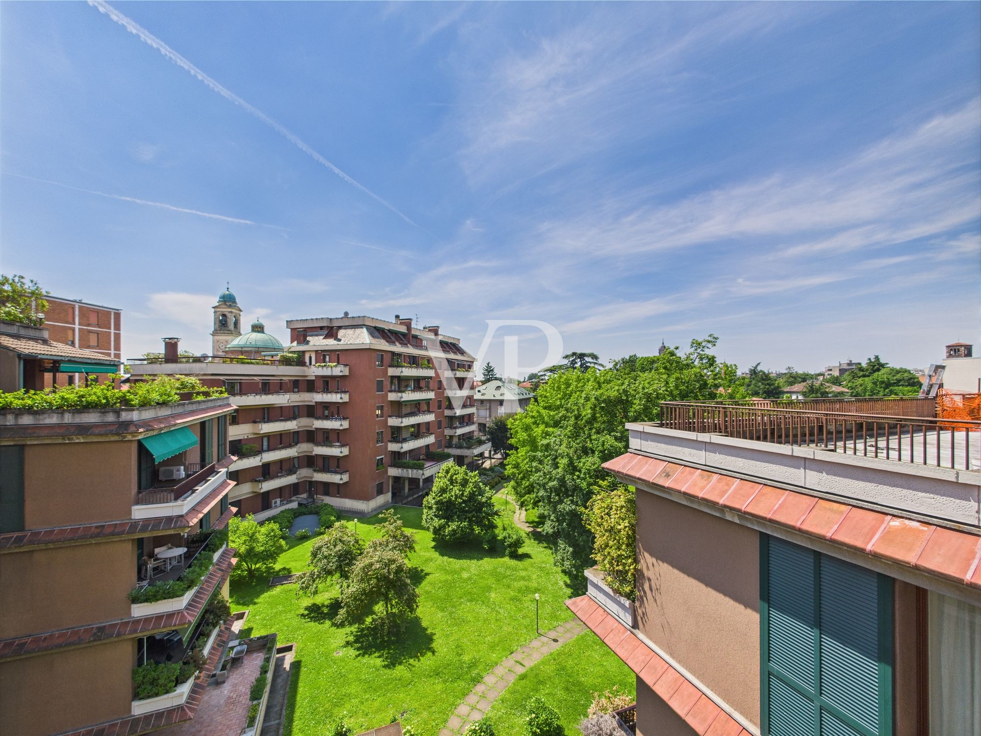 Vista da una camera da letto su un angolo di terrazzo e sul verde condominiale