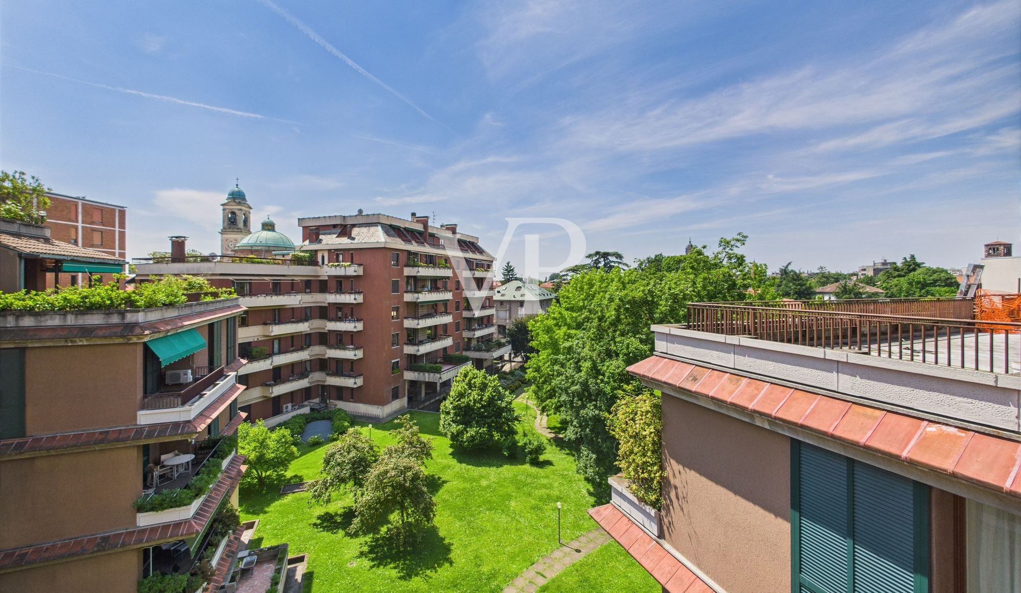 Vista da una camera da letto su un angolo di terrazzo e sul verde condominiale