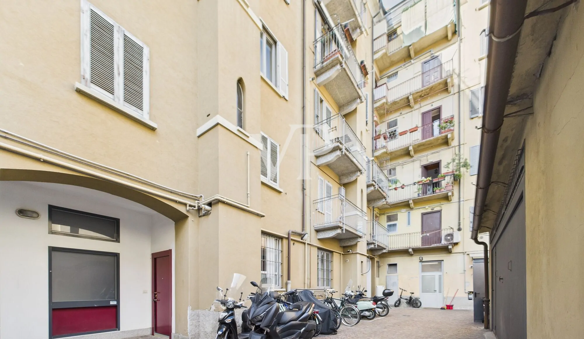 Cortile interno al palazzo con spazio moto e biciclette