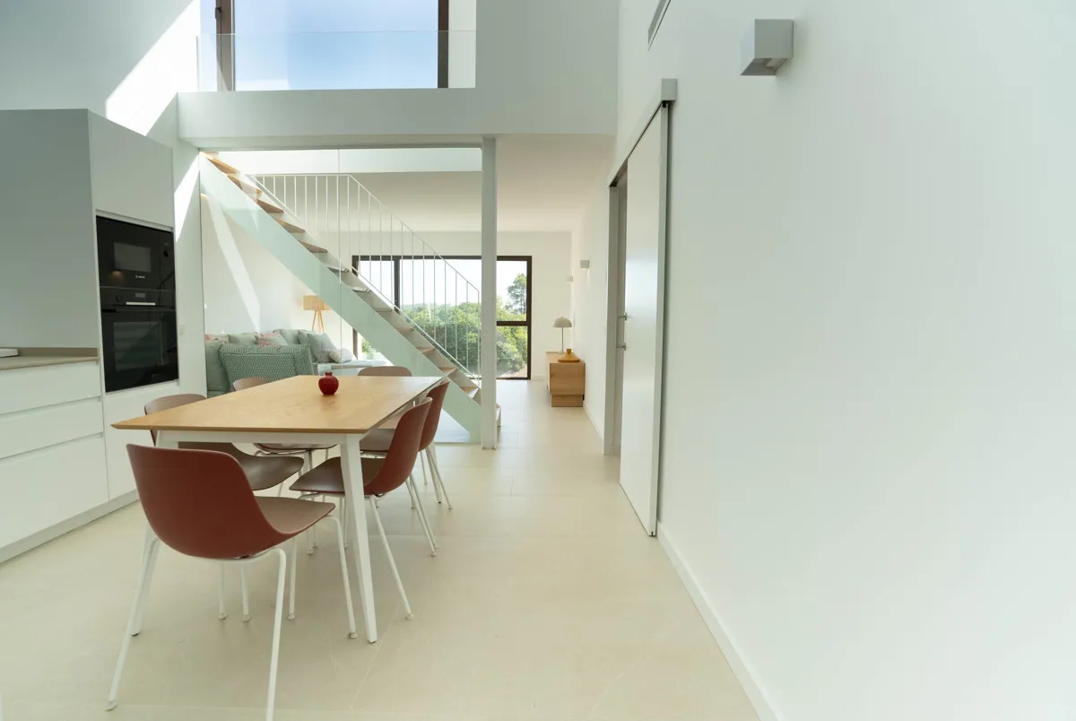 Open-plan living and dining area with stylish staircase to the sleeping area