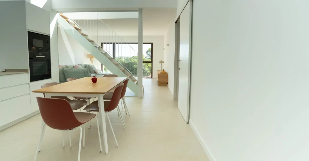 Open-plan living and dining area with stylish staircase to the sleeping area