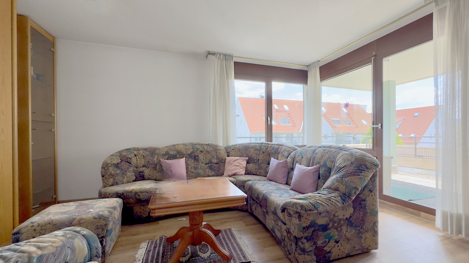 Wohnbereich mit Zugang zum überdachten Balkon mit vorhandener Einrichtung